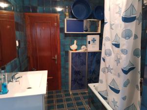a bathroom with a sink and a shower curtain at Hostal in Mieres