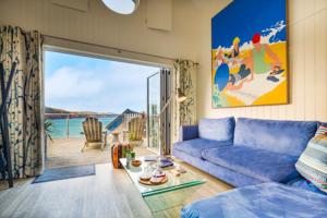 a living room with a blue couch and a large window at Cary Arms & Spa in Torquay