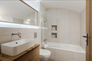 a white bathroom with a sink and a toilet at Sunlit Family Home in Hampstead in London