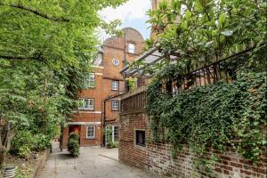 an old brick building with ivy growing on it at Sunlit Family Home in Hampstead in London