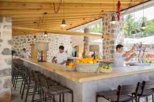 een groep mensen die aan een bar in een restaurant staan bij Hotel Es Port in Port de Soller