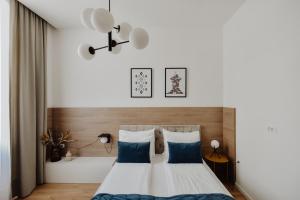 a bedroom with a large bed with blue pillows at Lux City Apartments & Rooms in Sarajevo