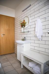 Baño blanco con lavabo y espejo en Setrið Guesthouse, en Borgarnes