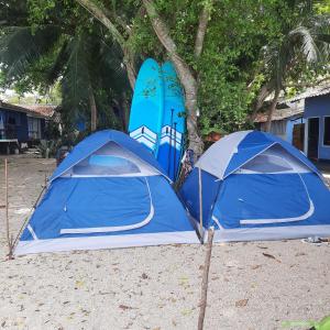 two blue tents on the beach with surfboards at Two Rocks Bungalows in Ban Tai