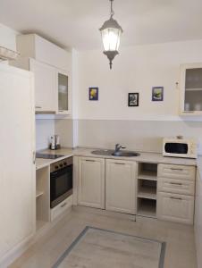 a kitchen with white cabinets and a sink at Golden Sands Rentals Apartments in Golden Sands