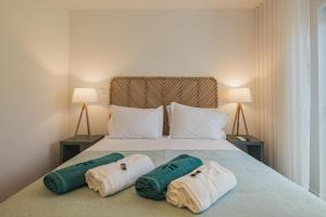 a bedroom with a bed with two towels on it at Alto do Forte in Ponta Delgada