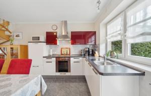 a kitchen with white cabinets and a sink and a window at 3 Bedroom Stunning Home In Haren Ems in Dankern