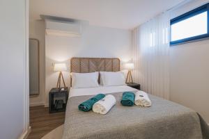 1 dormitorio con 1 cama con toallas en Alto do Forte en Ponta Delgada