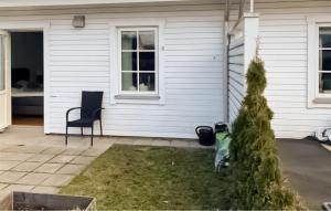 ein Haus mit einem Stuhl und einem Weihnachtsbaum im Hof in der Unterkunft 2 Bedroom Amazing Home In Mrbylnga in Mörbylånga