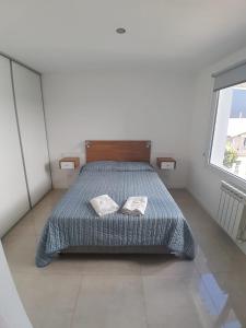 une chambre avec un lit avec deux oreillers dessus dans l'établissement Departamento centrico Bariloche - Rolando, à San Carlos de Bariloche