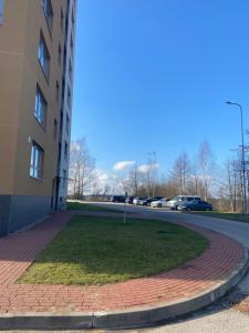 a grassy area next to a building next to a street at Eliana Apartments in Druskininkai