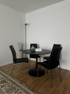 een tafel met vier stoelen en een laptop erop bij Captivating 2-Bed Apartment in Viby J in Viby