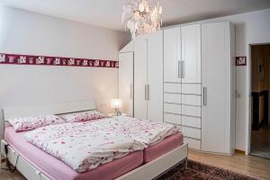 um quarto com uma cama grande e um lustre em Haus Helga em Idar-Oberstein