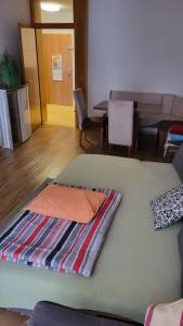 a large bed with an orange pillow on top of it at Stylish warm apartment in Villach
