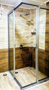 y baño con ducha y puerta de cristal. en La Nicholas Lake View by Summit Hotels, en Mawlyngkhung