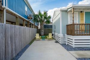 a patio with two chairs and a fence at Tranquil Cove in Port Aransas