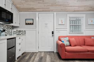 a living room with a red couch in a kitchen at Tranquil Cove in Port Aransas +23 photos