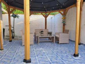 un patio con una mesa y sillas bajo un cenador en Casa Bonita, en Puerto Cortés