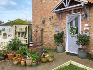 a bunch of potted plants in front of a house at Bramley Lodge Annex in Clenchwarton