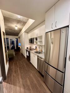 La cuisine est équipée de placards blancs et d'un réfrigérateur en acier inoxydable. dans l'établissement Flexhome East Side Studio UR2 - READ INFO, à Milwaukee