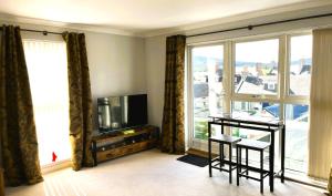 a living room with a tv and a large window at Entire flat in Banchory, Aberdeenshire, Scotland in Banchory