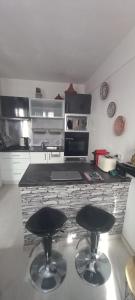 een keuken met twee barkrukken voor een aanrecht bij LE PHENIX Appartement calme et Cosy in Caen