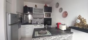 a kitchen with white cabinets and a counter top at LE PHENIX Appartement calme et Cosy in Caen