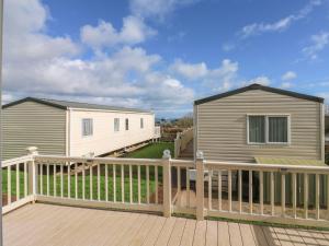 a mobile home on a deck next to a house at A La Mer in Paignton