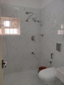 y baño blanco con ducha y aseo. en Bangalore Stays, en Bangalore