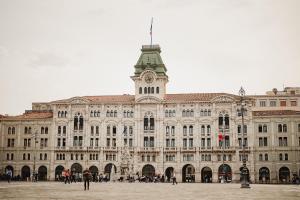 a large building with a clock tower on top of it at Monolocale Marina in centro storico in Trieste