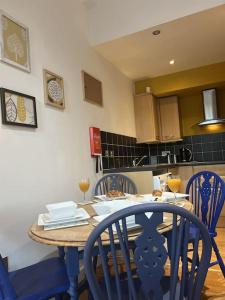 uma cozinha com uma mesa de madeira e cadeiras azuis em Millside Lodge - Easy walk to Shops, Attractions, em Burton upon Trent