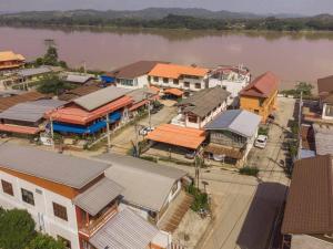 an aerial view of a town with houses and a river at บ้านพักเหมาหลังเชียงคาน ฮักเลย ฮักกัญ โฮมสเตย์ 1 - ຊຽງຄານ ຮັກເລີຍ ຮັກກັນ ໂຮມສະເຕ1 -Chiang Khan Hugloei HugKan Homestay1 in Chiang Khan