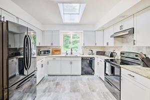 a kitchen with white cabinets and stainless steel appliances at Oasis Hot Tub Pool Game Room in Saylorsburg