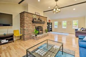 a living room with a brick fireplace and a blue couch at Oasis Hot Tub Pool Game Room in Saylorsburg