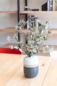 un vase noir et blanc avec des fleurs. dans l'établissement La Belle Vue : Duplex avec Terrasse,Jardin,Parking, à Annecy