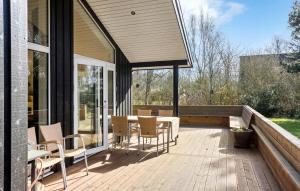 una terrazza in legno con tavolo e sedie. di Nice Home In Humble With Kitchen a Humble