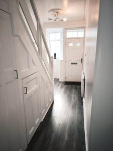 a hallway with a white door and a window at Spacious 3 Bedroom Home for Families and Contractors with Wi-Fi, Parking, Sleeps 7 - Clark Property Estates in Southend-on-Sea +16 photos