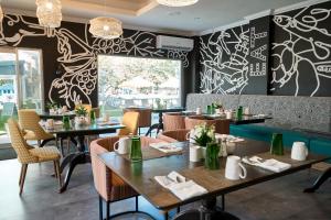 a restaurant with tables and chairs and a wall with graffiti at The Rockley by Ocean Hotels - Breakfast Included in Bridgetown