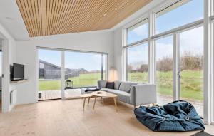 a living room with a couch and a table and windows at Nice Home In Haderslev With Wifi in Haderslev