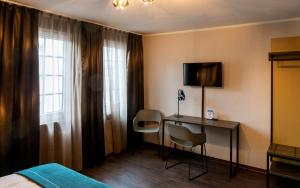 Habitación de hotel con cama y escritorio con TV. en Trip Inn Hotel Sachsenhausen, en Frankfurt