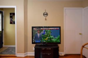 una TV a schermo piatto seduta su un supporto in camera di Sunny 4 Bed 2 Bath Providence a Providence