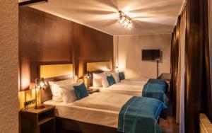 a hotel room with two beds with blue accents at Trip Inn Boutique Sachsenhausen in Frankfurt