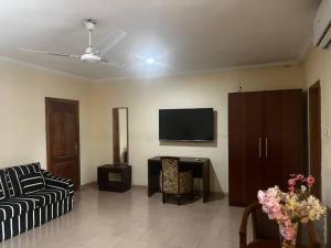 a living room with a couch and a flat screen tv at Amoaba's Inn in Akropong