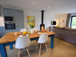 a kitchen and living room with a wooden table and chairs at Glebe Farm - West Putford in Bradworthy