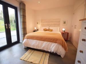 sypialnia z dużym łóżkiem i dużym oknem w obiekcie Glebe Farm - West Putford w mieście Bradworthy