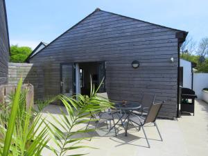 una pequeña casa negra con mesa y sillas en Glebe Farm - West Putford, en Bradworthy