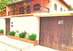 a house with a wooden garage door with a sign on it at Espaço Ideal de Itaipuaçú in Maricá