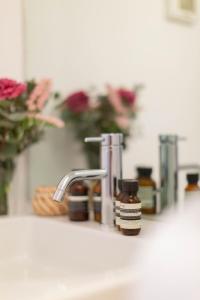 a bathroom sink with a bottle of soap next to a faucet at Pantheon Luxury House - ZEN 28 in Rome +33 photos
