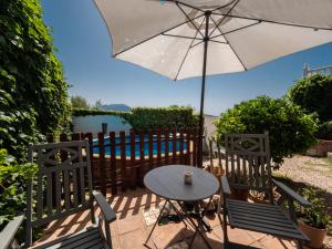 mesa y 2 sillas con sombrilla en La casa de Alma: stunning views and swimming pool, en Málaga