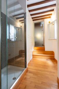 La salle de bains est pourvue d'une douche en verre et de parquet. dans l'établissement Pantheon Luxury House - Zen Real Estate, à Rome